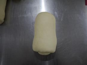 松弛好的面团擀成长条，椭圆形。然后卷起，再松弛15分钟。