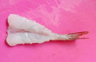 从中间破开，但不要切断，去除虾线和虾肠。