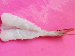 从中间破开，但不要切断，去除虾线和虾肠。