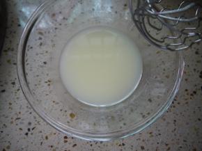 玉米油和水倒入打蛋盆中，用手动打蛋器搅拌均匀至乳化。用打蛋器顺着一个方向画圈就可以乳化完成了。此时可以开始预热烤箱，上下火165度。