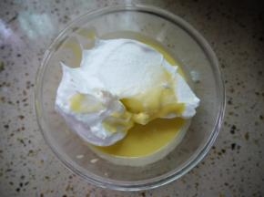 把3分之1的蛋白霜加入到蛋黄糊中，用刮刀翻拌均匀，动作要快。翻拌就是用刮刀以写J字的方式，从2点的角度划到8点的角度，同时打蛋盆以逆时针的方向慢慢转动。