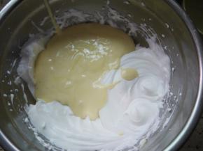 然后把拌好的蛋糕糊倒入到剩余的蛋白霜中，继续用刮刀翻拌均匀。