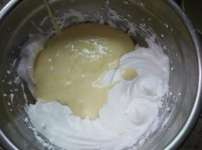 然后把拌好的蛋糕糊倒入到剩余的蛋白霜中，继续用刮刀翻拌均匀。