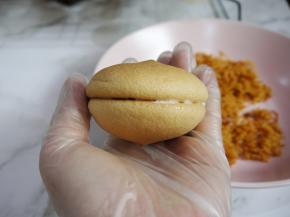 带上手套，拿一片蛋糕、在底部抹上一层沙拉酱，然后把另一片合上。