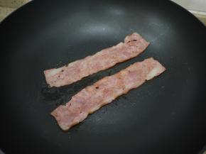 把准备好的蔬菜洗干净，番茄切片备用。然后锅里放一点点油，把培根煎熟备用。