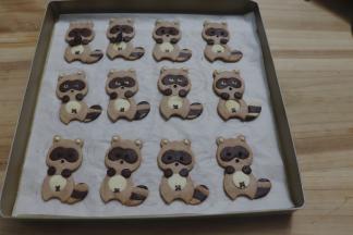 剪小小口，黑巧克力给小浣熊画上眼珠、鼻子，以及肚脐眼，白巧克力画上耳朵、眼睛，黑巧克力在上面点睛。