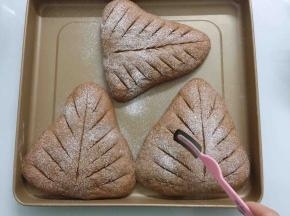 发酵好的面包胚用面粉筛筛上薄薄一层低筋面粉，用锋利的刀片割上自己喜欢的纹路