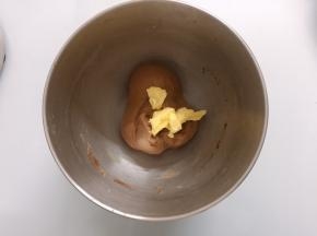 面团表面揉至表面光滑后加入软化的黄油，开低档揉至黄油完全融合于面团