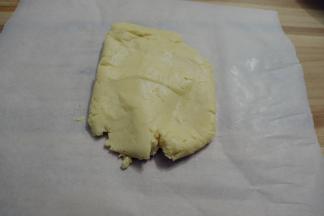 用刮刀拌至无干粉,用手将面团揉成团，放在油纸上。