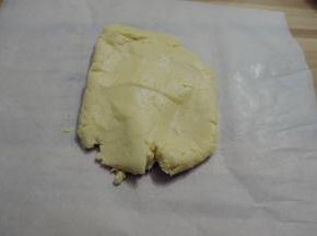 用刮刀拌至无干粉,用手将面团揉成团，放在油纸上。