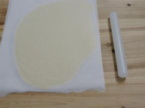 用擀面杖将面团擀成薄片，盖上油纸，放入冰箱冷藏30分钟