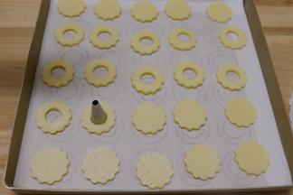 中间用小号的裱花嘴大头那边在面团中间压个圆孔。中间要孔的饼干2：1没压圆孔的饼干。