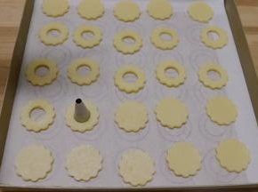 中间用小号的裱花嘴大头那边在面团中间压个圆孔。中间要孔的饼干2：1没压圆孔的饼干。