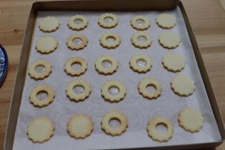 将熬好的糖水倒入1/2个中间有圆孔的饼干胚内，记得留一半的圆孔饼干不要倒糖水。放至艾素糖水凉透变硬