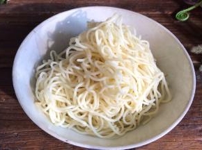 把浸泡的面条捞出，沥干水分后装入碗中