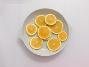 橙子先用盐搓洗后用水冲干净，清除部分蜡质表层，用刀切成薄片