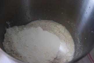 揉面盆中加入牛奶，干酵母，搅匀，放入面粉。