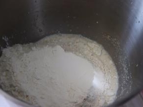 揉面盆中加入牛奶，干酵母，搅匀，放入面粉。
