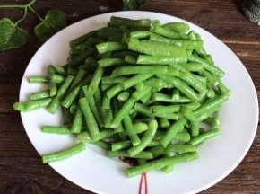 浸泡好的豆角，捞出切成小段，装入盘中