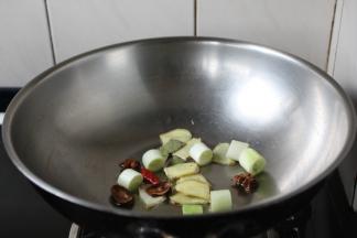 热锅凉油（20ml），先煸炒姜片、八角、草果、小茴香，煸炒出香味，然后再煸炒葱段，葱段被煸炒出香味即可。