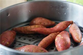 将地瓜洗净，上锅蒸至熟透。同样的玉米也是一样要蒸好先。