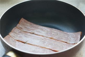 将培根先无油小火煎烙至出味。