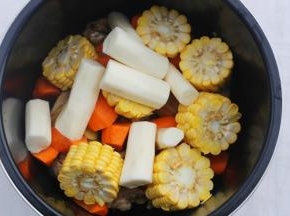 鸡肉连同姜片一起放入锅中，加上胡萝卜、玉米、山药