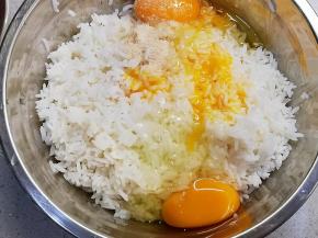 三只鸡蛋的蛋黄放入白米饭中，加入一小勺鸡粉、一小勺盐，全部材料拌匀