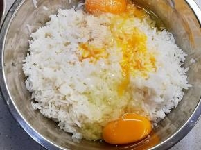 三只鸡蛋的蛋黄放入白米饭中，加入一小勺鸡粉、一小勺盐，全部材料拌匀