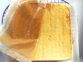 蛋糕降至手温时，将蛋糕翻转个面，底下记得铺上一张油纸，之后揭掉蛋糕上的油纸
