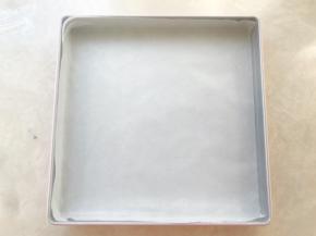 首先准备一张油纸，平铺在方盘内，边角可以用剪刀剪开
