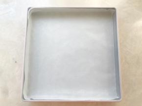 首先准备一张油纸，平铺在方盘内，边角可以用剪刀剪开
