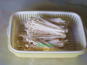 金针菇去根部1厘米长，根部有发黄，建议不要吃，我一般切去，然后用手一根一根撕开，清水洗净，捞出沥干水。金针菇拍水，不能久泡，容易坏。