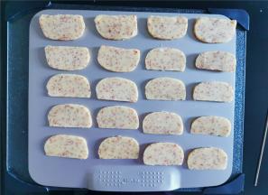 冻硬后用刀切成均匀厚度的片状，放置学厨的烤盘中进行烤制。