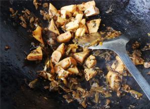 把鱼豆腐切三角块，倒入锅中跟酸菜一起翻炒。