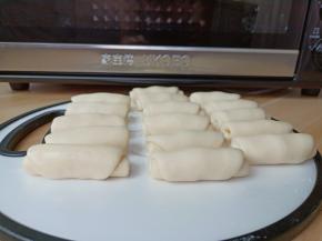 取包好的面团，封口朝上擀成长条，从上往下卷起做好的面团盖保鲜膜醒10分钟【每用一个其他的盖保鲜膜盖好防止面团表皮变干】