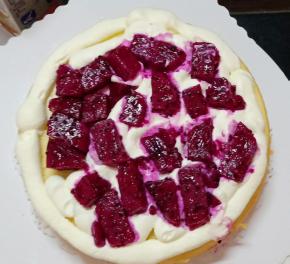 边缘挤一圈淡奶油，铺满红心火龙果块。