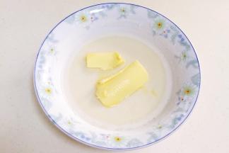 取出蒸好的麻薯，放至温凉，加入黄油，用手把黄油揉进麻薯内。