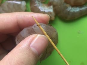 用牙签把虾线挑出来，挑虾线的技巧是在虾的第三节那里，找准虾线的位置，把牙签插进去一挑，轻轻一拉，虾线就出来了。