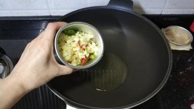 锅里热油倒入剁碎的配料
