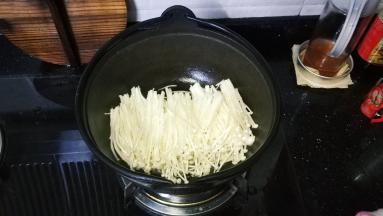 锅里先放上一层金针菇