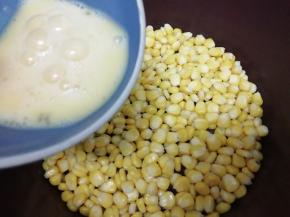 然后把打散的鸡蛋液均匀的洒在玉米粒上，煎到看见鸡蛋液凝固