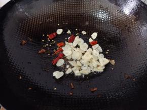 锅中留少许底油，下蒜片，麻椒，辣椒炒出香味