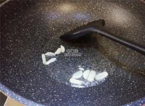 热锅冷油，升温后，把蒜瓣片放入爆香翻炒下。
