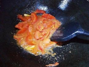 接着把切块的番茄倒入锅中翻炒，要记住这步，用锅铲把番茄捣碎，成糊状。