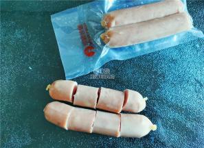 首先把香肠解冻，用厨房纸吸干水分，切四小份。