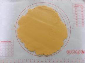 松弛好派皮放上案板，用擀面杖擀成比派盘略大的圆形