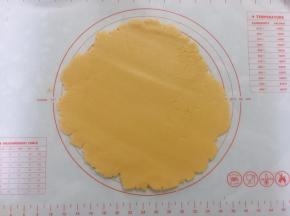 松弛好派皮放上案板，用擀面杖擀成比派盘略大的圆形