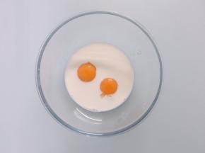 开始制作布丁馅，碗中加入鸡蛋黄、细砂糖和牛奶，搅拌至糖融化