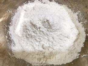 盆里加入糯米粉和粘米粉，先用100克开水烫面，再加入冷水揉成面团
